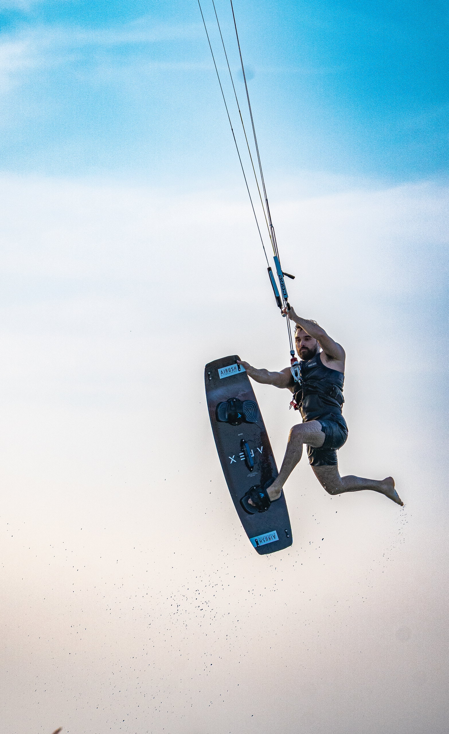 Kitesurfer high above the water mid-jump