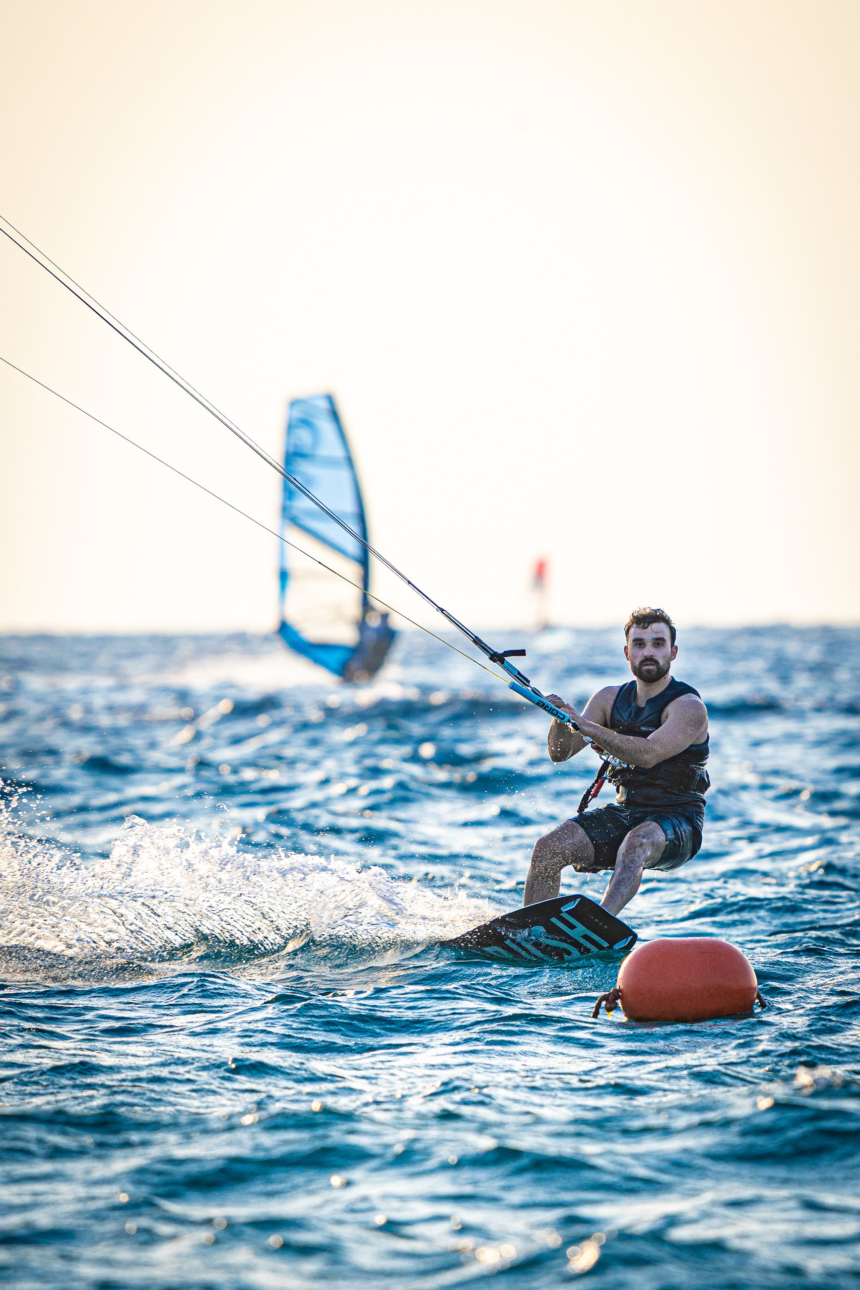 Kitesurfer powering upwind past the fleet