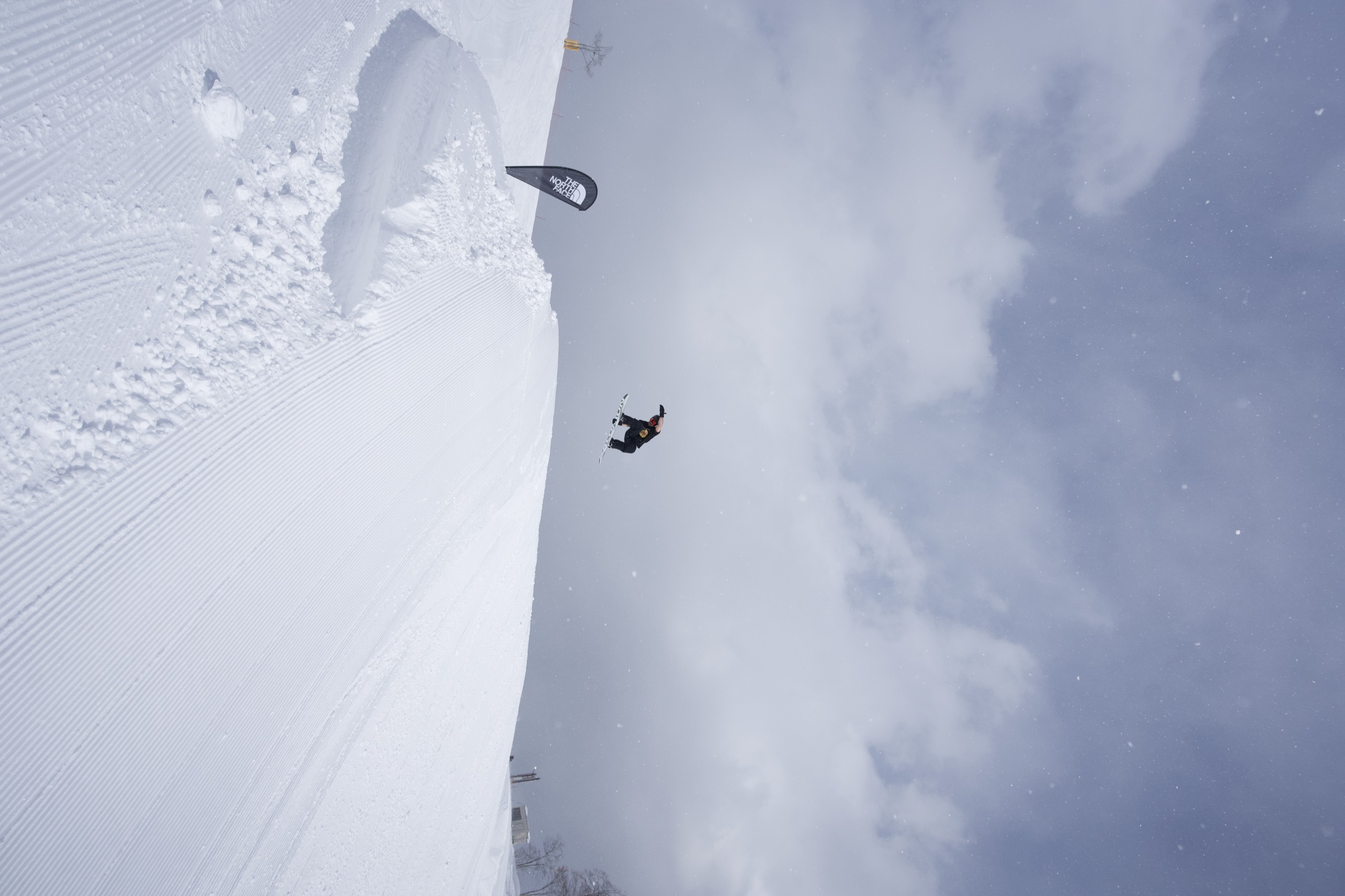 A lone snowboarder crossing a slope in a whiteout