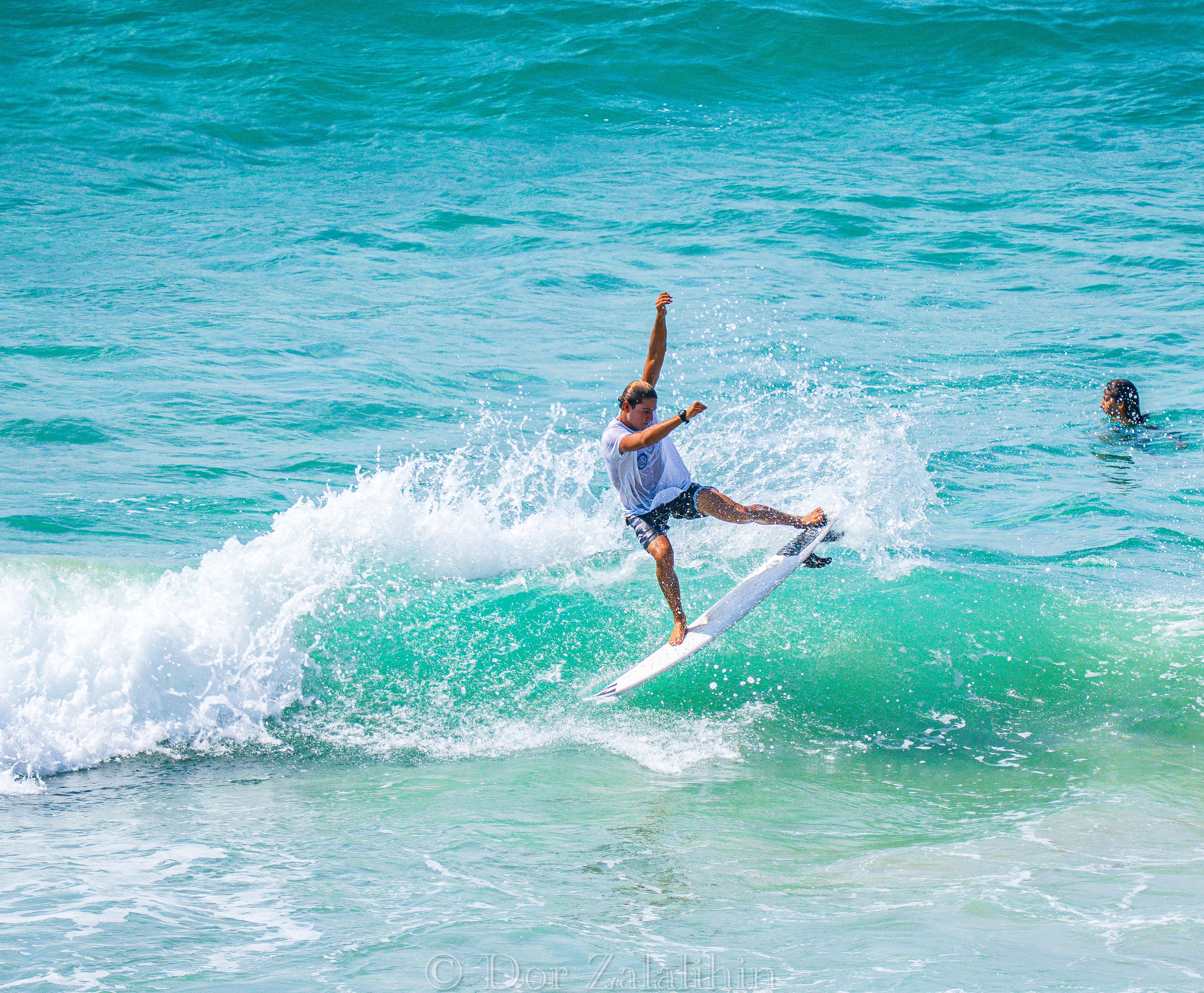 Surfer cutting back on a turquoise wall