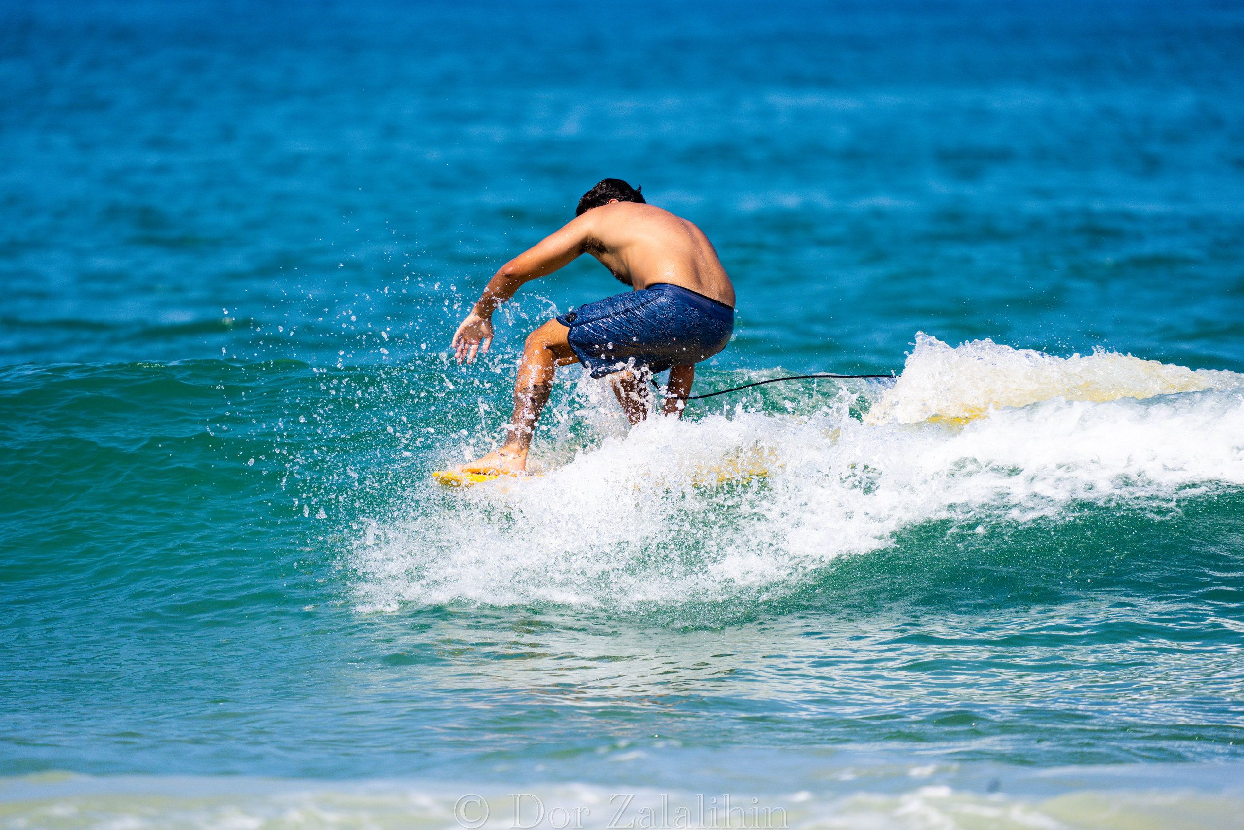 Surfer driving off the bottom of a wave